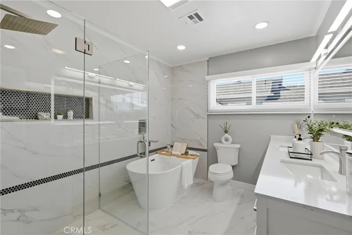 The recently remodeled primary bathroom features elegant porcelain tile flooring.