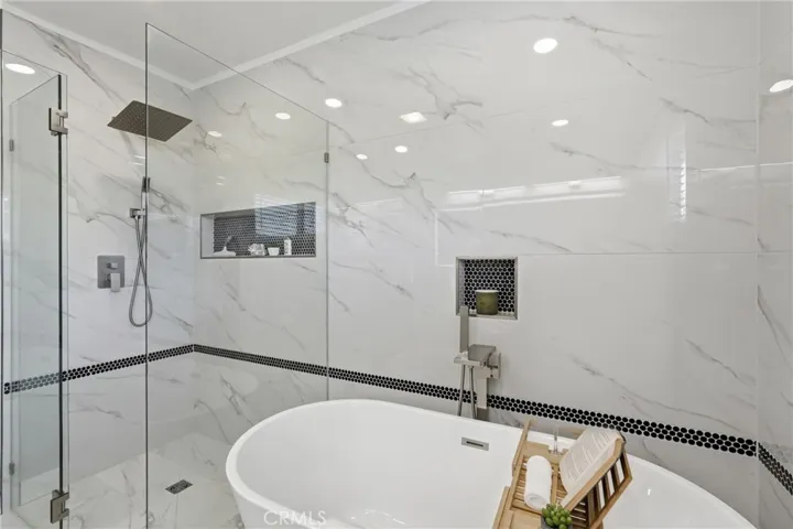 Unwind in the freestanding soaking tub or refresh in the walk-in shower, thoughtfully designed with a curbless entry and sleek frameless glass.