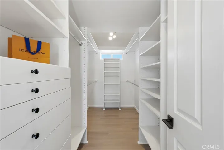 The primary suite features a spacious custom closet with built-in organization, overhead storage, and ample space.