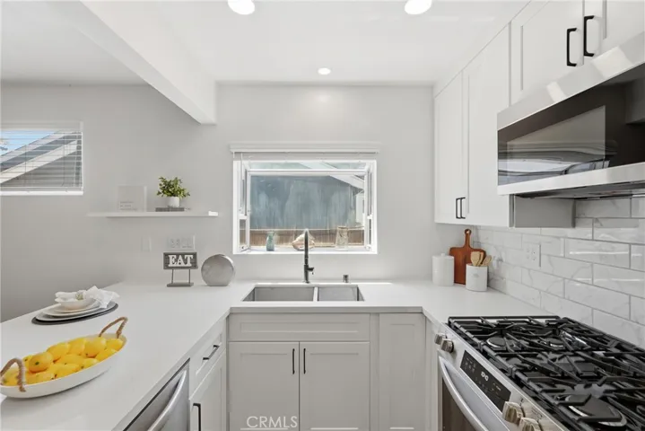 The kitchen also features soft-close white shaker cabinetry for a clean, timeless look.