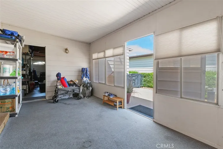 Sunroom shows one door into 2-car garage and another out to "back" (side) patio