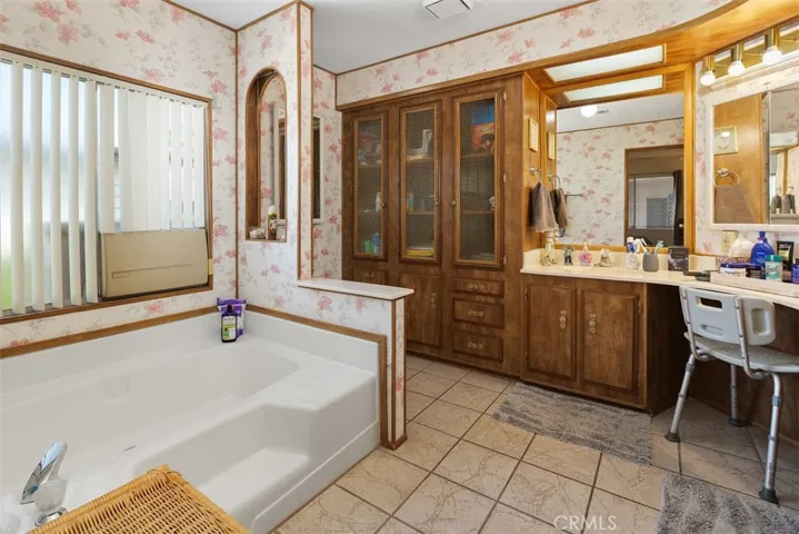 Primary bathroom has a socaking tub, dual sink + vanity seating area