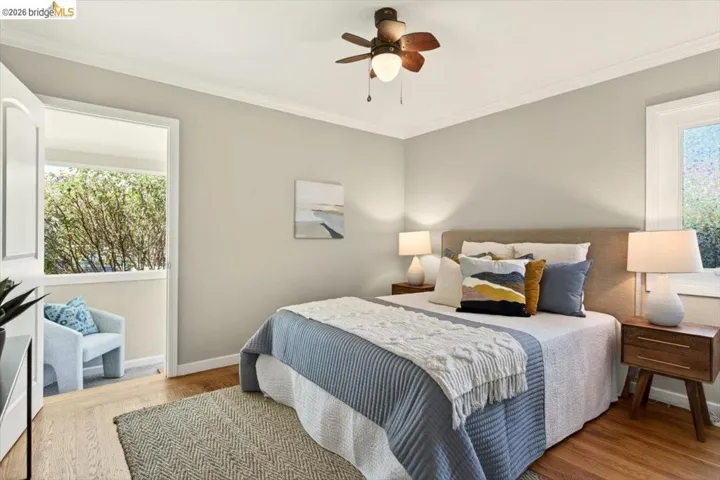 Bedroom featuring crown molding, light wood-type flooring, and ceiling fan