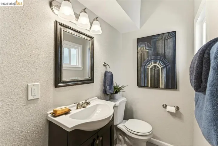 Half bathroom with vanity and a textured wall