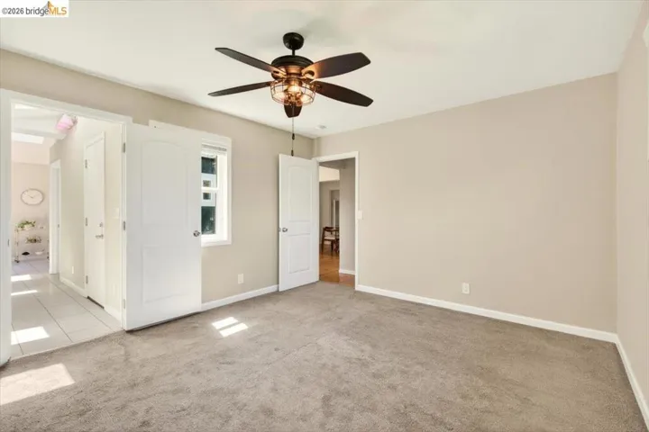 Unfurnished bedroom featuring light carpet and a ceiling fan