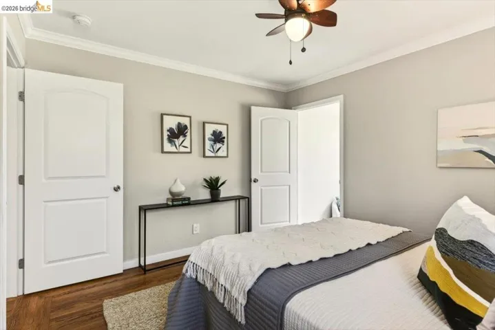 Bedroom featuring ornamental molding, dark wood finished floors, and a ceiling fan