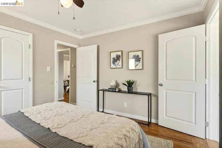 Bedroom featuring ornamental molding, dark wood finished floors, and ceiling fan