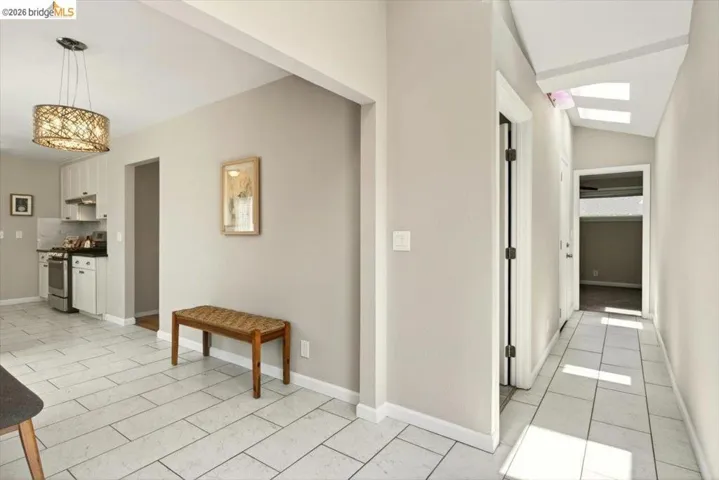 Hallway featuring lofted ceiling and light tile patterned floors