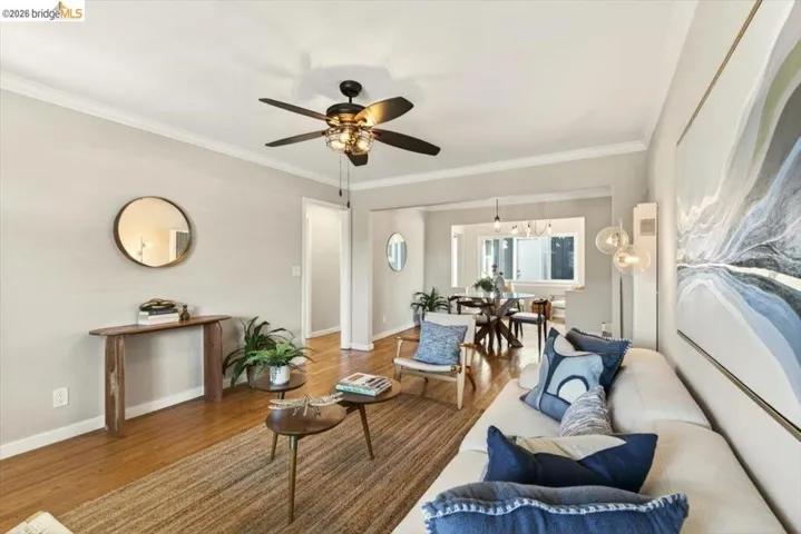 Living area with wood finished floors, crown molding, and ceiling fan