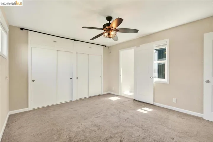 Unfurnished bedroom with multiple closets, carpet floors, and ceiling fan