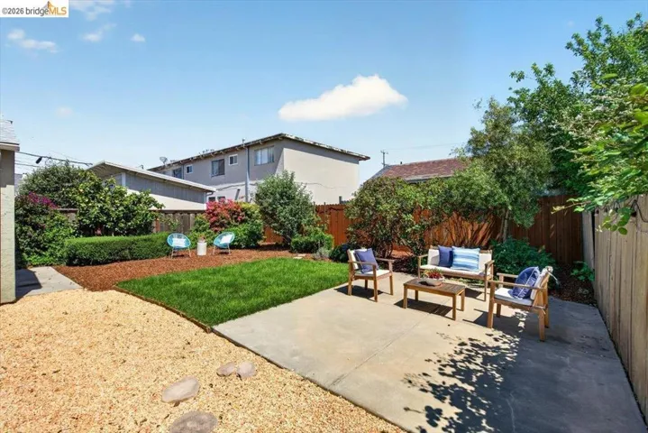 Fenced backyard with an outdoor living space and a patio area