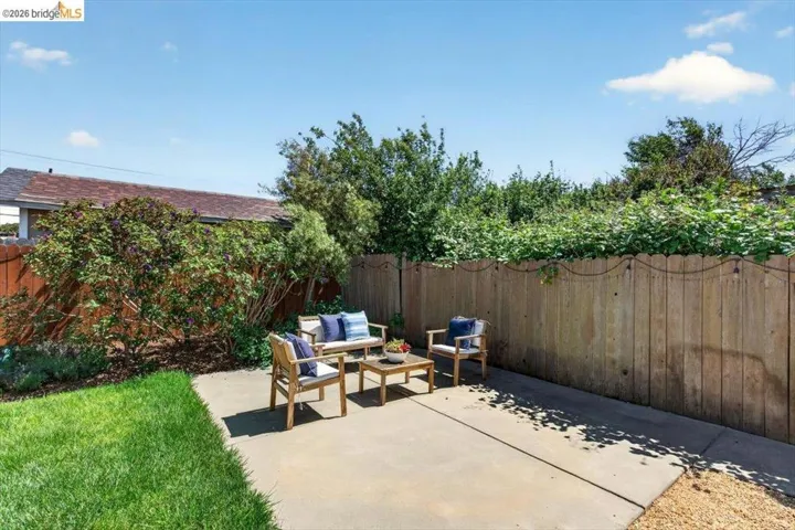 Fenced backyard with outdoor seating and a patio