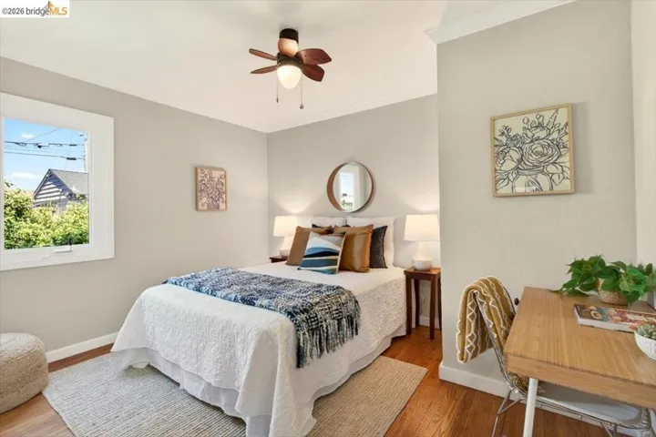 Bedroom featuring wood finished floors, ornamental molding, and ceiling fan