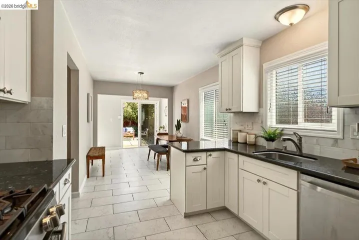 Kitchen with decorative backsplash, stainless steel appliances, and dark stone counters