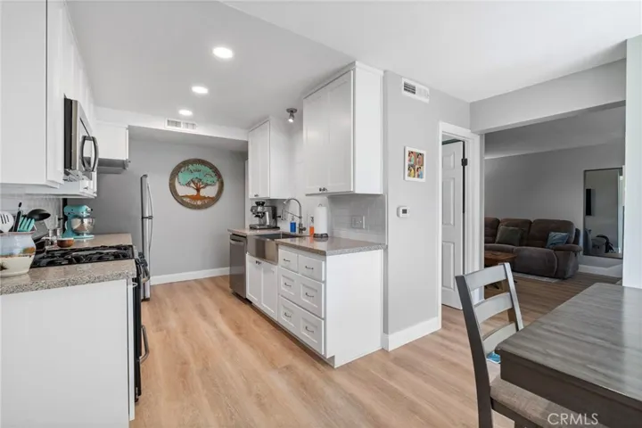 Remodeled kitchen with stainless steel appliances, stainless farmhouse sink, soft closing drawers and quartz countertops