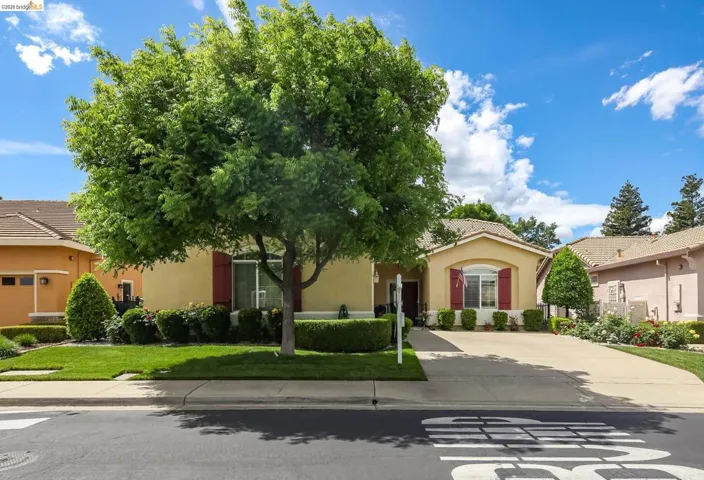 View of front of house with stucco siding, a front yard, and a tiled roof