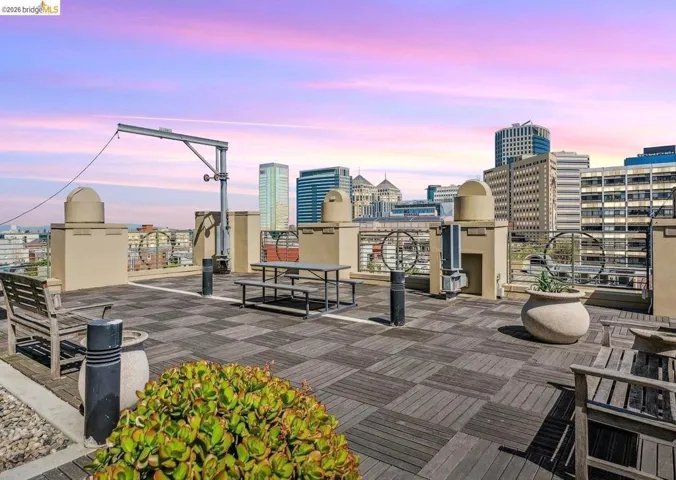 Patio terrace at dusk with a city view and a roof deck