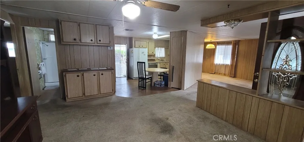 View from the doorway of the enclosed porch towards the kitchen and guest bathroom.