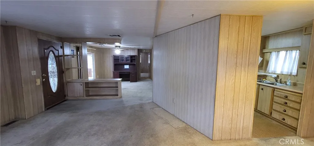 View of front door and pony wall to family room area, border wall with kitchen. Remove these two walls to make the unit much more spacious. (see closed unit #391 for improvement ideas)