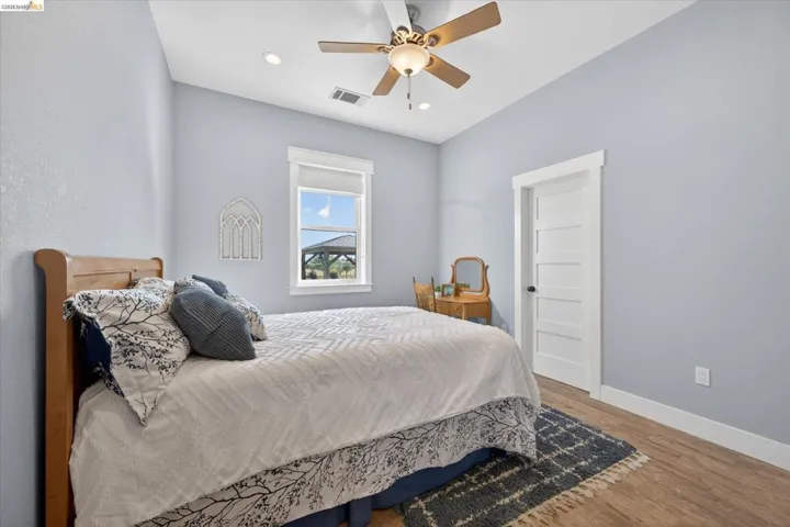 Bedroom with wood finished floors, ceiling fan, and recessed lighting, walk in closet