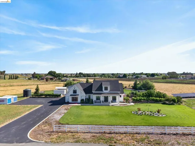 View of front facade with a view of rural / pastoral area, a front yard, and asphalt driveway
