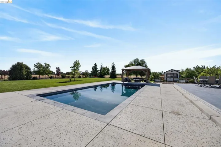Swimming pool featuring a gazebo, a patio area, and a yard