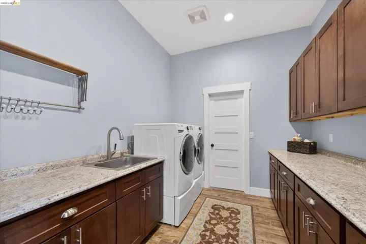 Laundry room featuring cabinet space, light wood-type flooring, and washing machine and clothes dryer