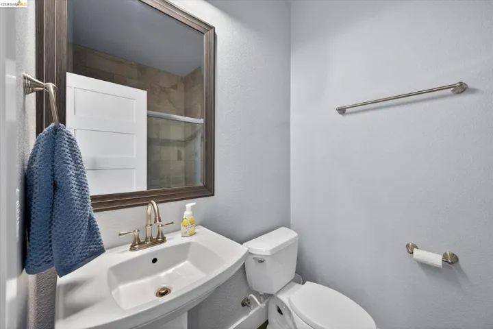 Bathroom with a textured wall and toilet, upstairs on suite