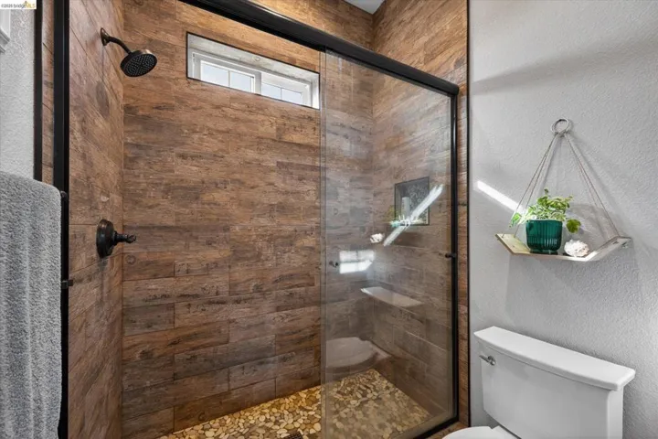 Bathroom with a textured wall and a stall shower