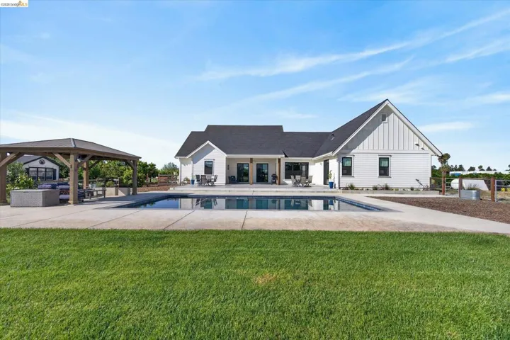 Back of property featuring a patio, a gazebo, and a lawn