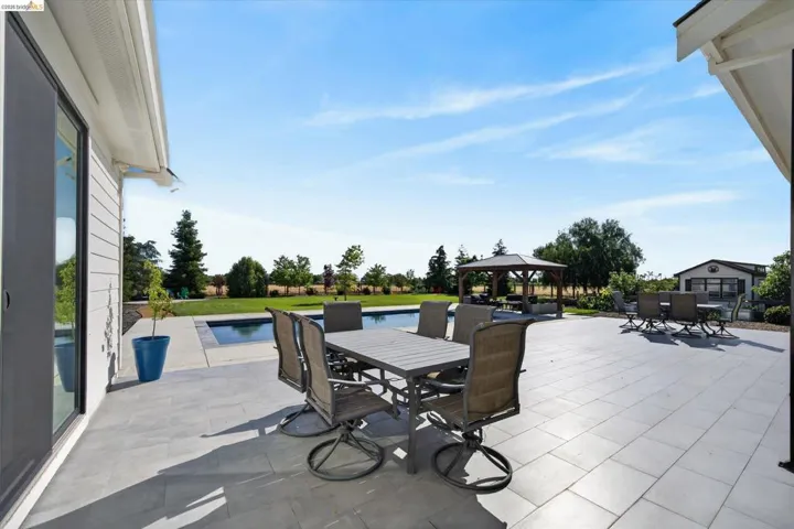 View of patio / terrace featuring outdoor dining area, a gazebo, and an outdoor pool