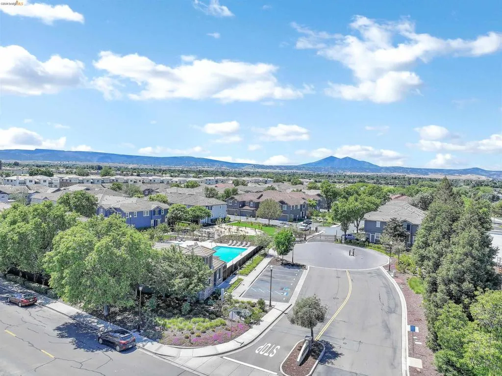 Aerial view of a residential community featuring a central swimming pool and surrounding green spaces