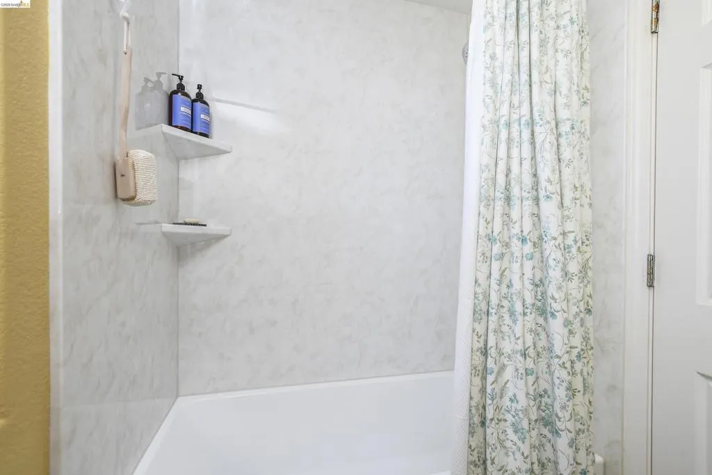 Bathtub with white surround and integrated corner shelving