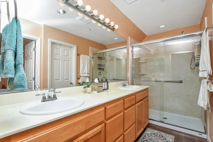 Bathroom featuring a dual-sink vanity with light wood-finish cabinetry and a light-toned countertop