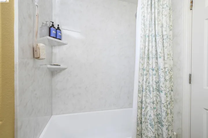 Bathtub with white surround and integrated corner shelving