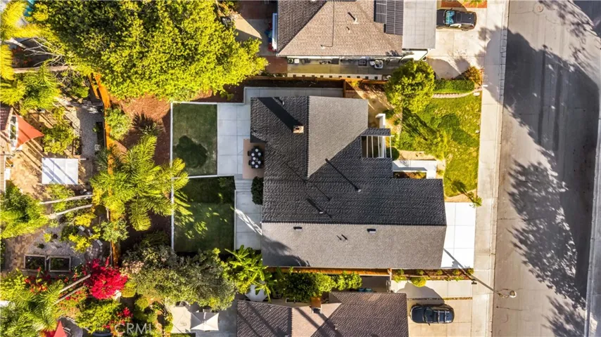 Overhead view of the property showcasing the lush landscaping, spacious driveway, and surrounding outdoor space.