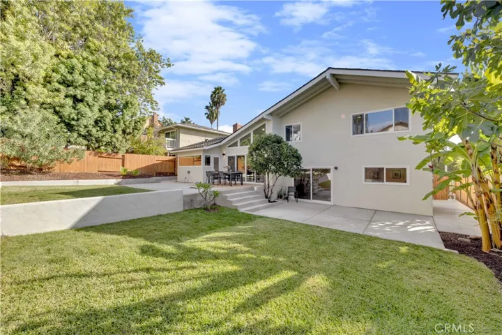 A wide view of the entire backyard, highlighting the large grass area and inviting space for gatherings or play.