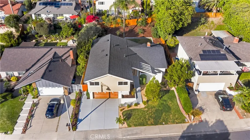 Aerial view of the property, highlighting the spacious front yard, surrounding neighborhood, and well-maintained exterior.