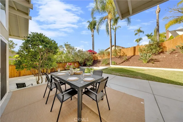 The spacious patio area, perfect for outdoor dining and relaxation, showcasing the beautifully landscaped backyard