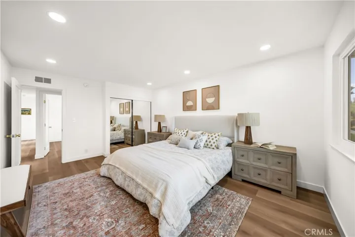 Spacious master bedroom with natural light, featuring ample closet space, modern decor, and a cozy, inviting atmosphere.