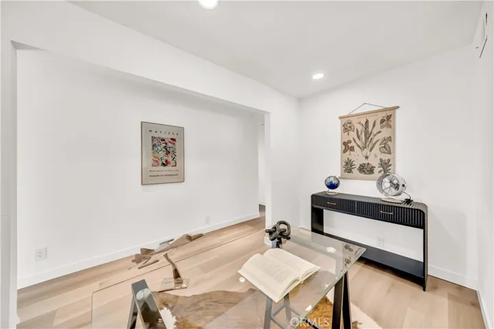 Another view of the home office, showcasing the clean, minimalist design with ample natural light and modern furniture for a productive workspace.
