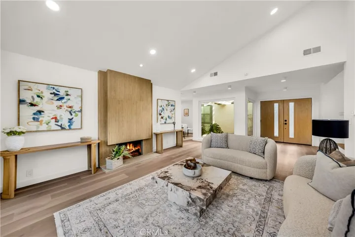Bright and spacious living room with modern fireplace and high ceilings.