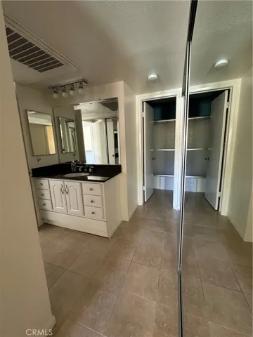 Bathroom with vanity with separate toilet area and two closets