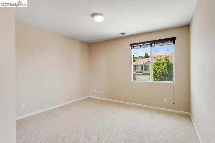 Spare room featuring light colored carpet and baseboards