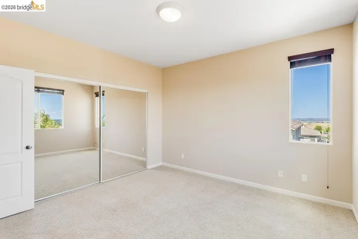 Unfurnished bedroom featuring light colored carpet and a closet