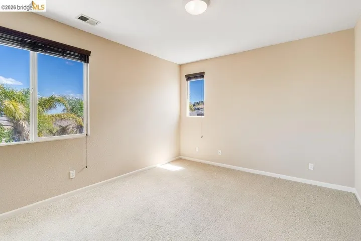 Empty room featuring baseboards and light carpet