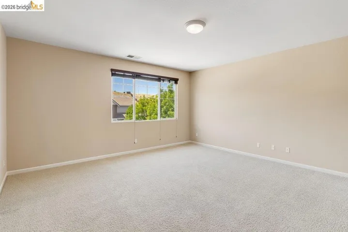Unfurnished room with baseboards and light colored carpet