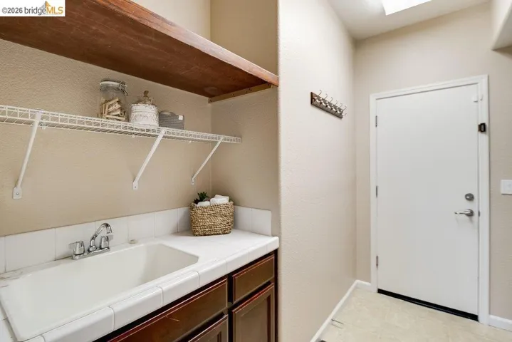 Laundry room with a sink and a textured wall