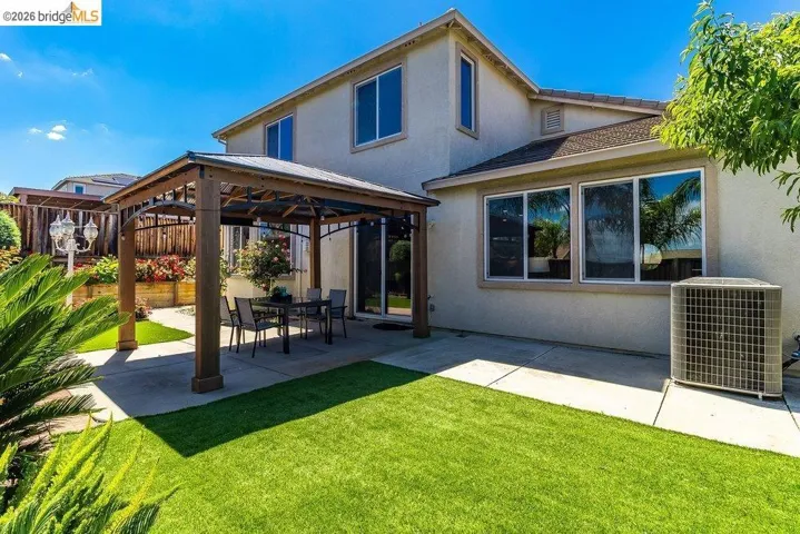Rear view of house featuring a gazebo, a patio area, and stucco siding