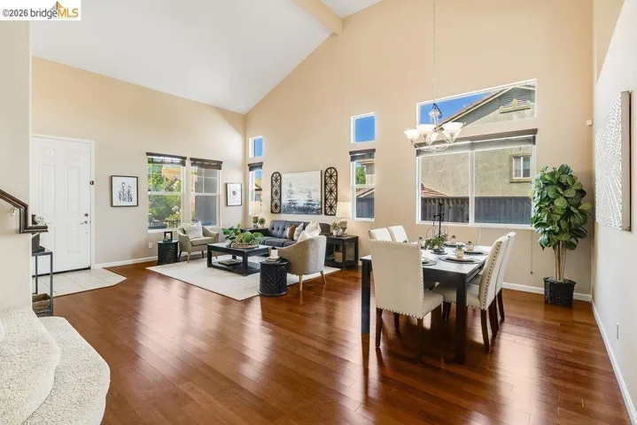 Dining room with wood-type flooring, suspended lighting, and lofted ceiling